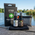 PB Products Carp Care Kit with Mouth Care and Body Care sprays, microfibre towel and hygienic zip bag beside the box at the lakeside